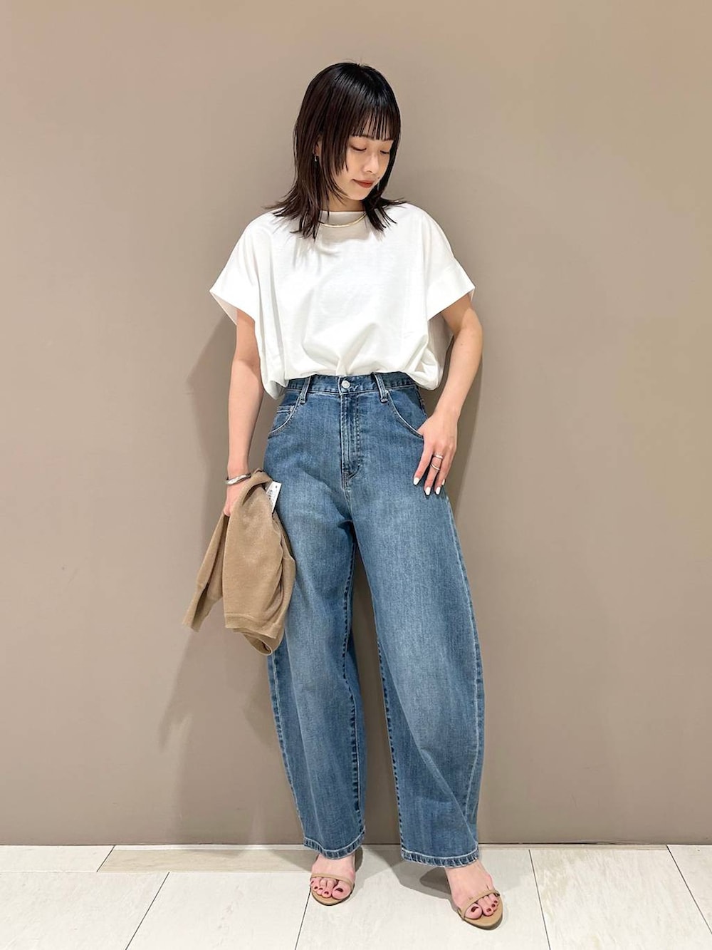 ベージュ系のスリッポン、イエロー系のショルダーバッグ、ブルー系のデニムパンツを着用したレディースの夏コーディネートの3枚目の写真