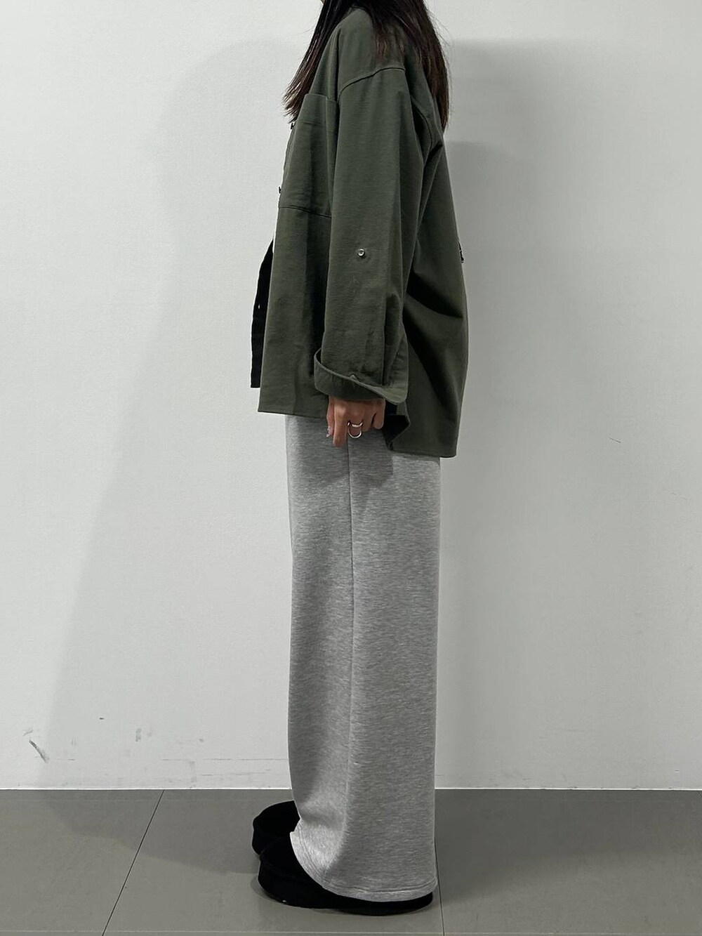 ブラック系のショルダーバッグ、ブラック系のスリッポン、グレー系のTシャツ/カットソーを着用したレディースの冬コーディネートの2枚目の写真