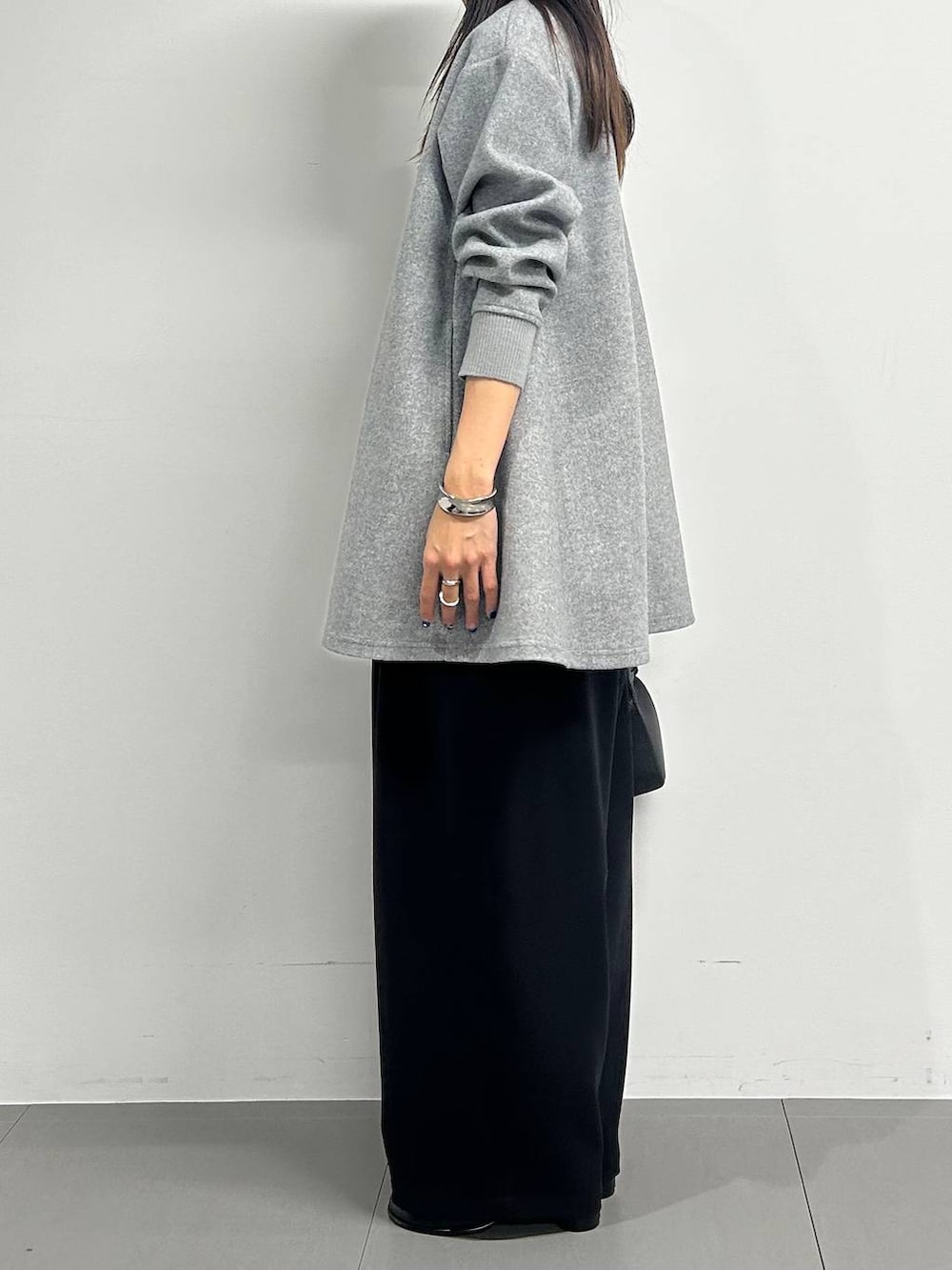 ブラック系のショルダーバッグ、ブラック系のブーツ、グレー系のTシャツ/カットソーを着用したレディースの冬コーディネートの2枚目の写真