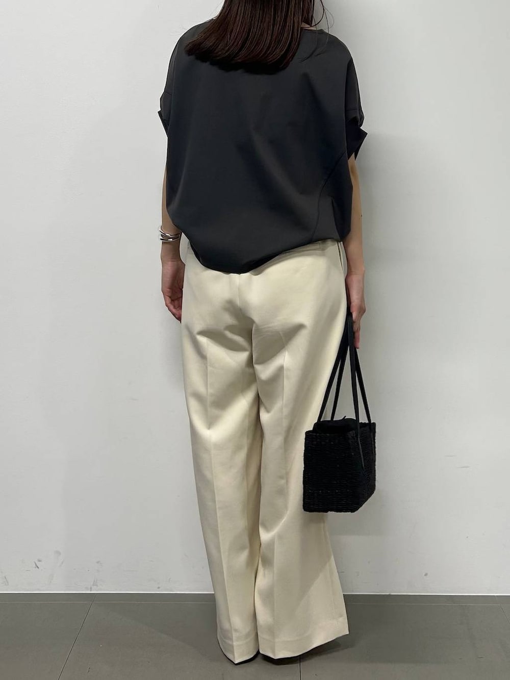 グレー系のTシャツ/カットソー、ホワイト系のその他パンツ、ブラック系のサンダルを着用したレディースの春コーディネートの3枚目の写真