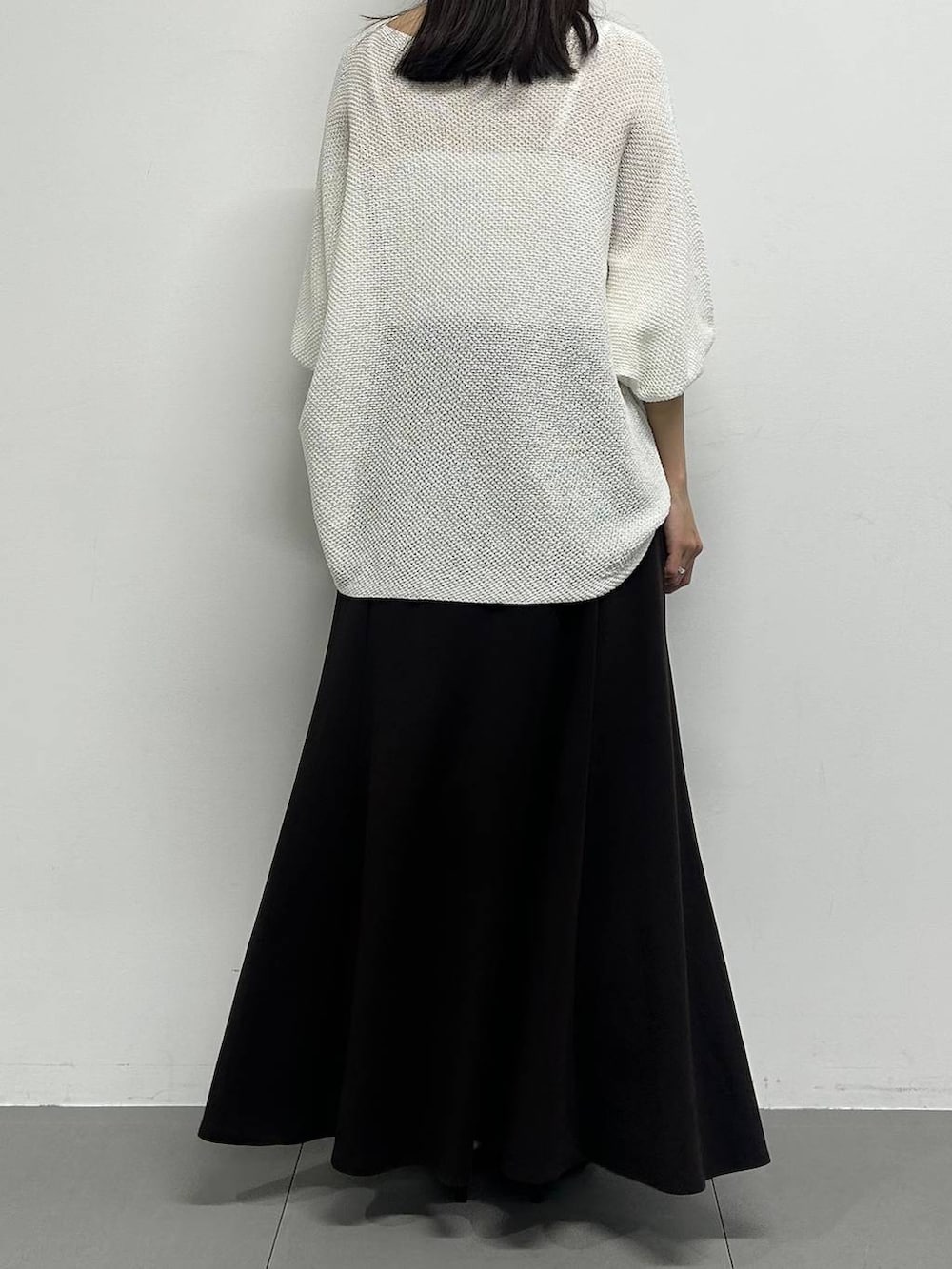 ホワイト系のニット/セーター、ブラック系のサンダル、ベージュ系のかごバッグを着用したレディースの春コーディネートの3枚目の写真