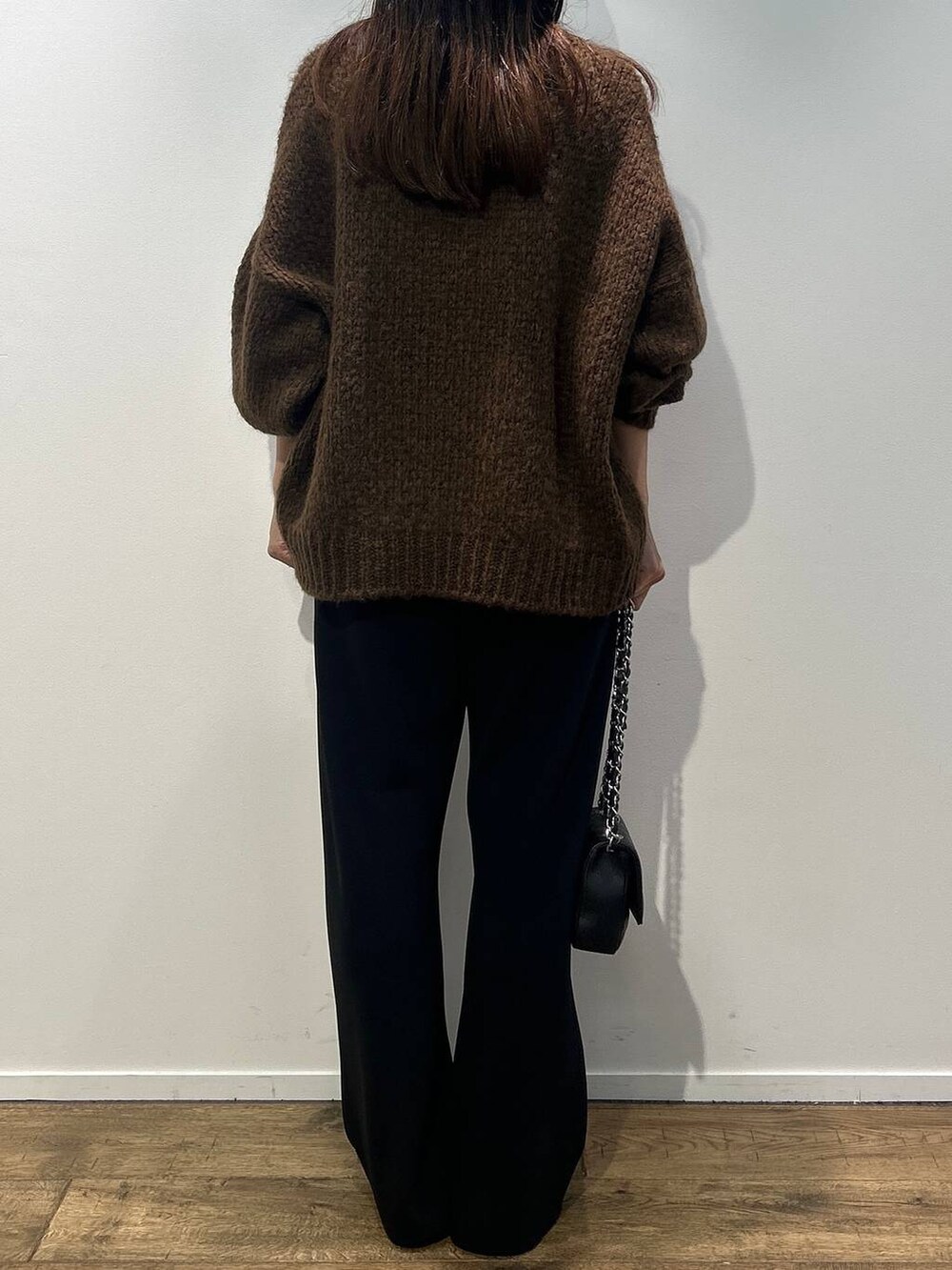 ブラック系のハンドバッグ、ブラウン系のニット/セーター、ブラック系のその他パンツを着用したレディースの秋コーディネートの4枚目の写真