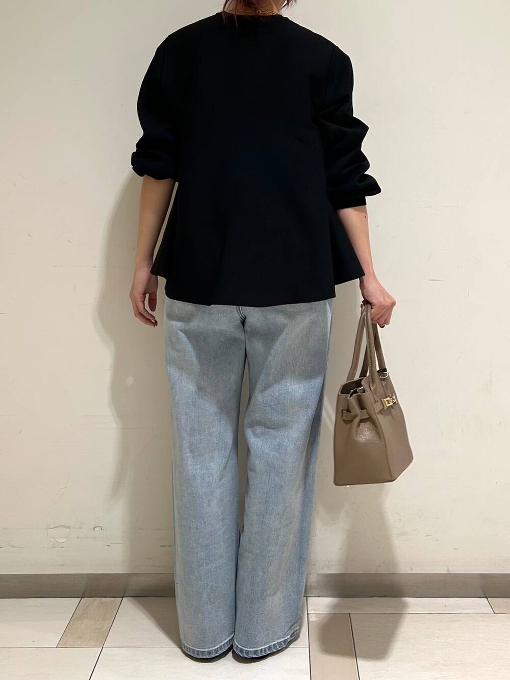 シルバー系のローファー、ブルー系のデニムパンツ、ブラック系のニット/セーターを着用したレディースの冬コーディネートの3枚目の写真