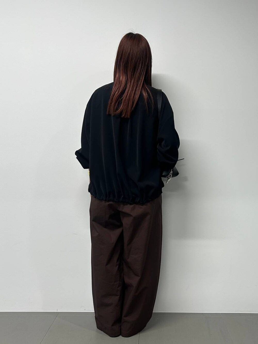 ブラック系のショルダーバッグ、ブラック系のブルゾン、その他のネックレスを着用したレディースの春コーディネートの3枚目の写真