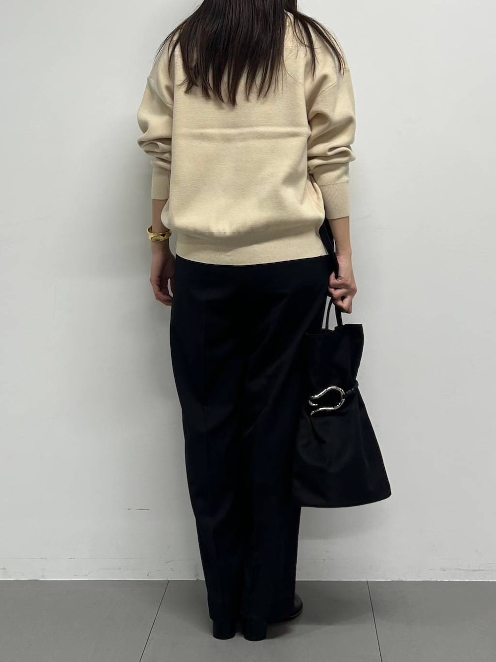 ホワイト系のカーディガン/ボレロ、ブラック系のスラックス、ゴールド系のチョーカーを着用したレディースの冬コーディネートの3枚目の写真