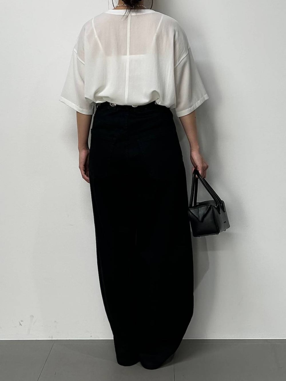 シルバー系のローファー、ホワイト系のシャツ/ブラウス、ブラック系のハンドバッグを着用したレディースの夏コーディネートの3枚目の写真