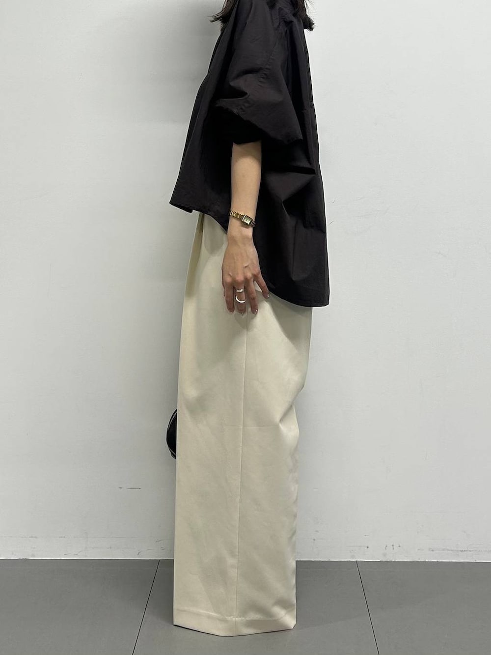 ブラウン系のシャツ/ブラウス、ブラック系のハンドバッグ、ホワイト系のその他パンツを着用したレディースの春コーディネートの2枚目の写真