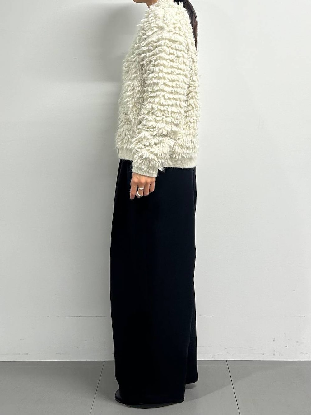 ブラック系のブーツ、ブラック系のその他パンツ、ホワイト系のカーディガン/ボレロを着用したレディースの冬コーディネートの2枚目の写真