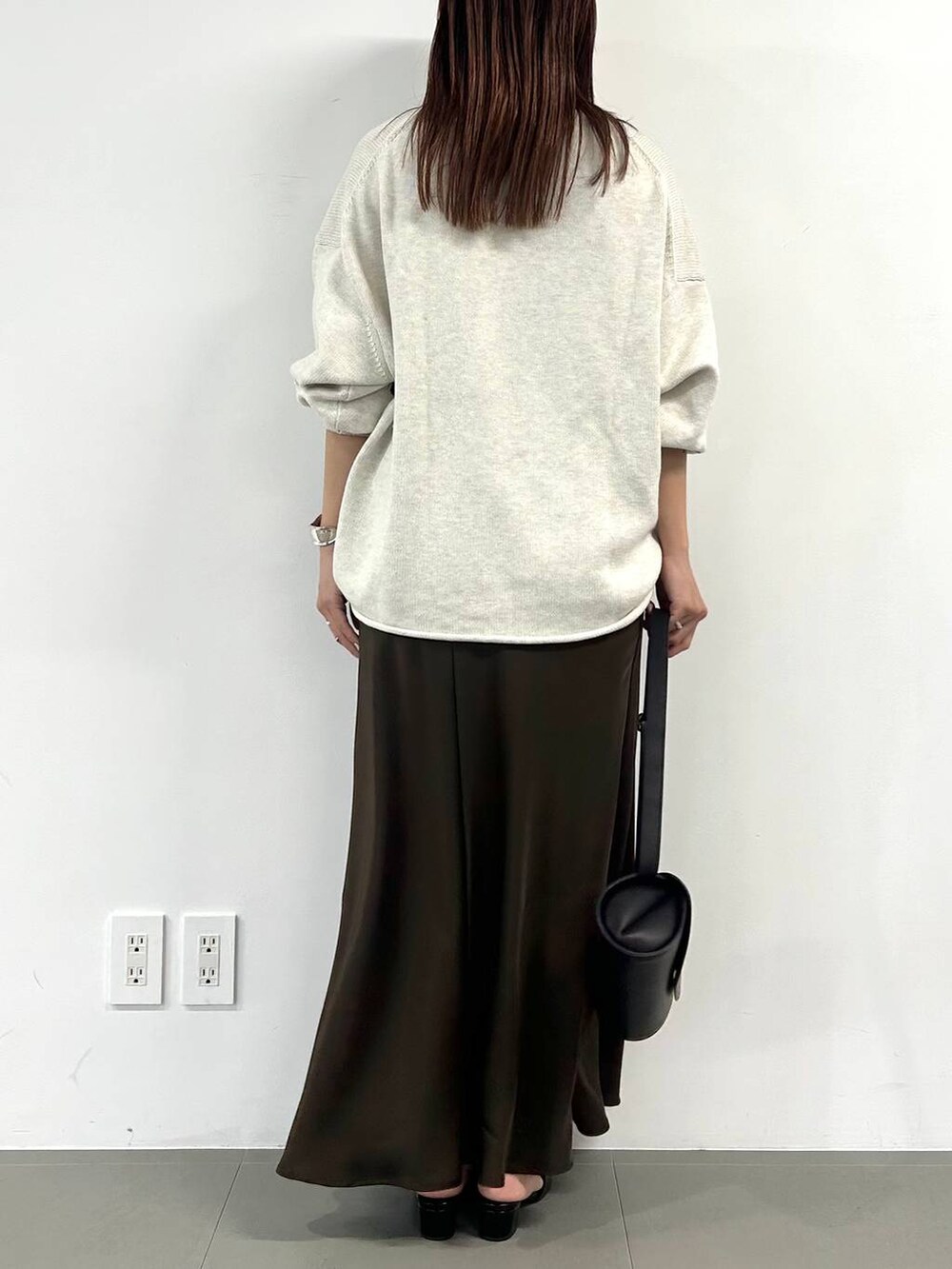 ベージュ系のニット/セーター、ブラック系のショルダーバッグ、ブラウン系のスカートを着用したレディースの冬コーディネートの3枚目の写真