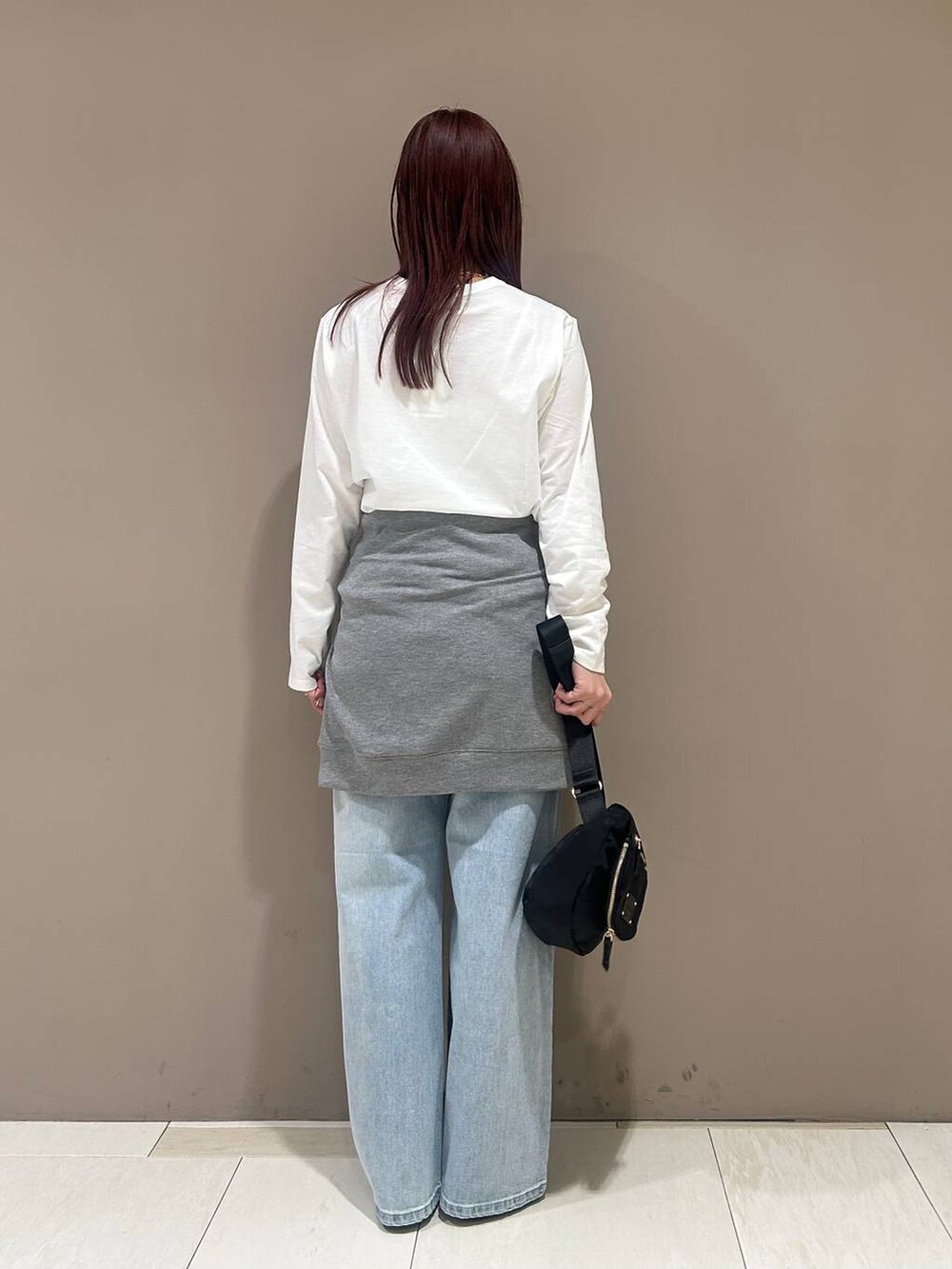 シルバー系のローファー、ブルー系のデニムパンツ、ブラック系のボディバッグ/ウエストポーチを着用したレディースの冬コーディネートの3枚目の写真