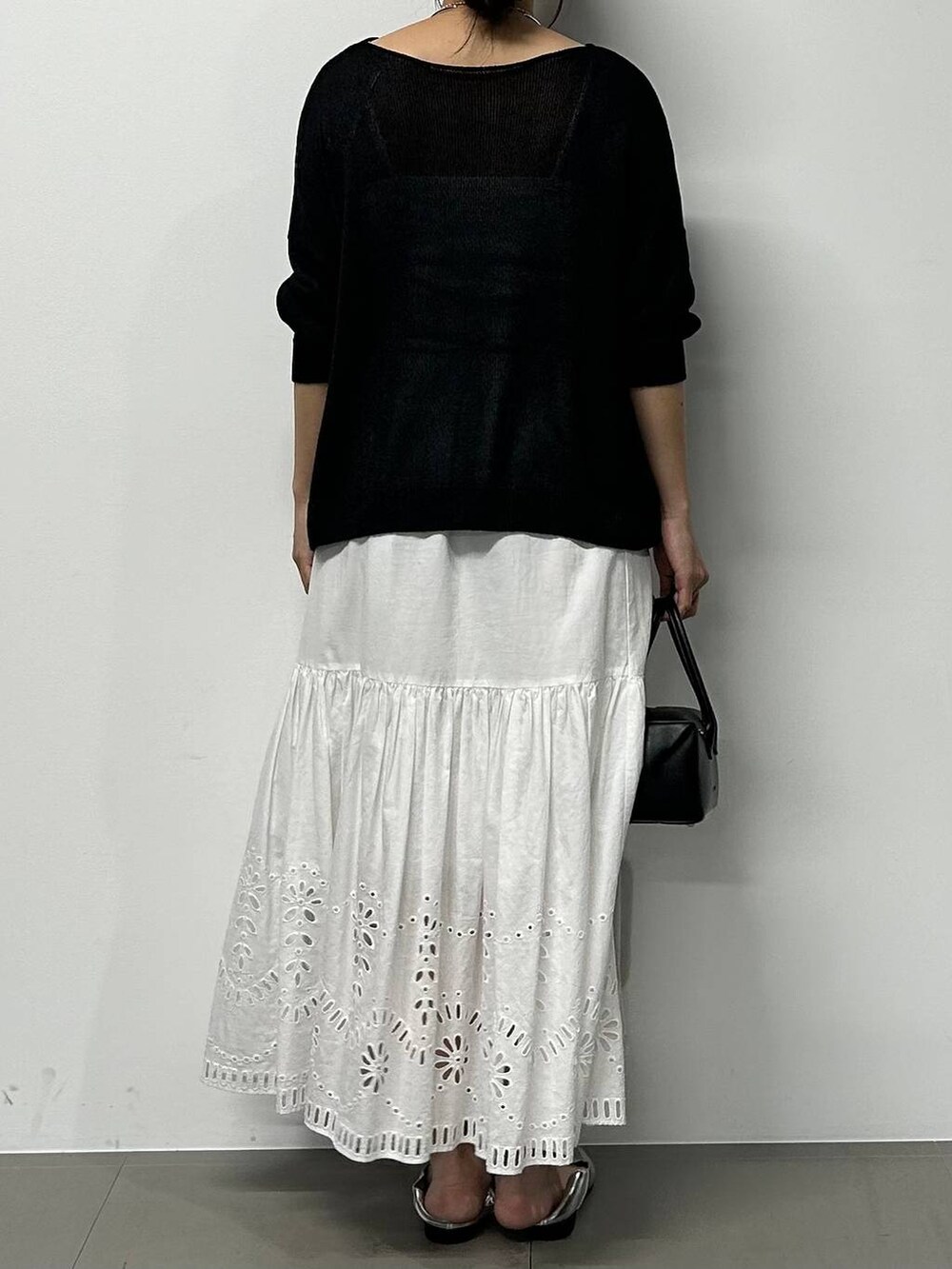 シルバー系のローファー、ブラック系のハンドバッグ、ブラック系のニット/セーターを着用したレディースの夏コーディネートの3枚目の写真