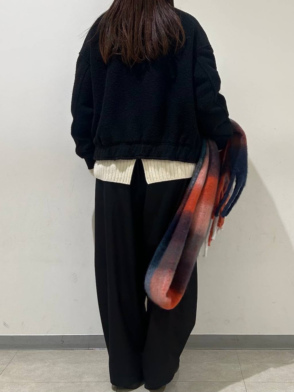 ブラック系のブルゾン、ホワイト系のニット/セーター、ブラック系のその他パンツを着用したレディースの冬コーディネートの3枚目の写真