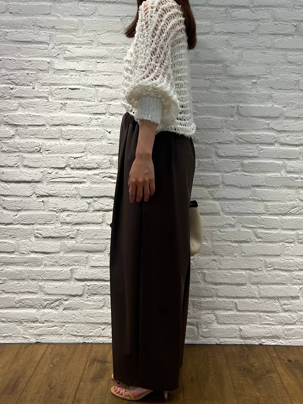 ブラウン系のその他パンツ、ホワイト系のトートバッグ、ホワイト系のニット/セーターを着用したレディースの夏コーディネートの2枚目の写真