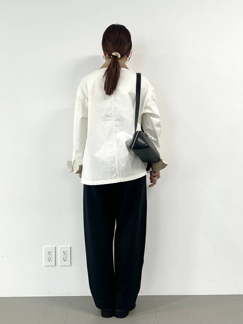 ブラック系のショルダーバッグを着用したレディースの冬コーディネートの3枚目の写真