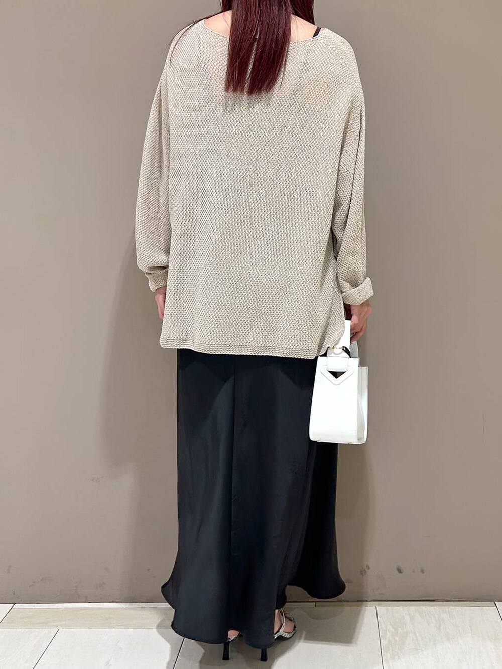 ホワイト系のハンドバッグ、ベージュ系のニット/セーター、その他のサンダルを着用したレディースの春コーディネートの3枚目の写真