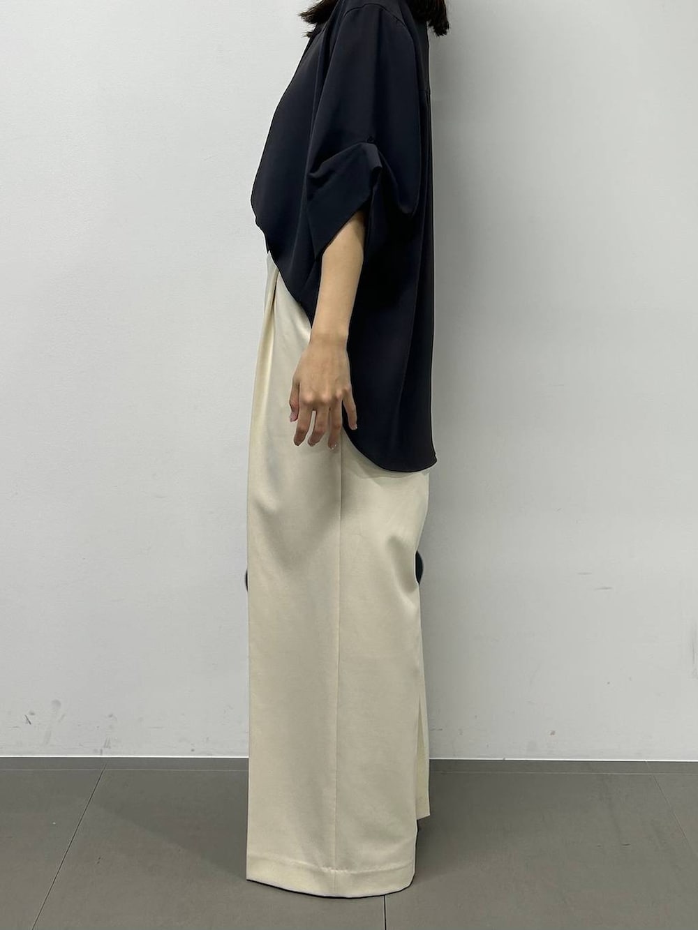 ブラック系のハンドバッグ、グレー系のシャツ/ブラウス、ホワイト系のその他パンツを着用したレディースの春コーディネートの2枚目の写真