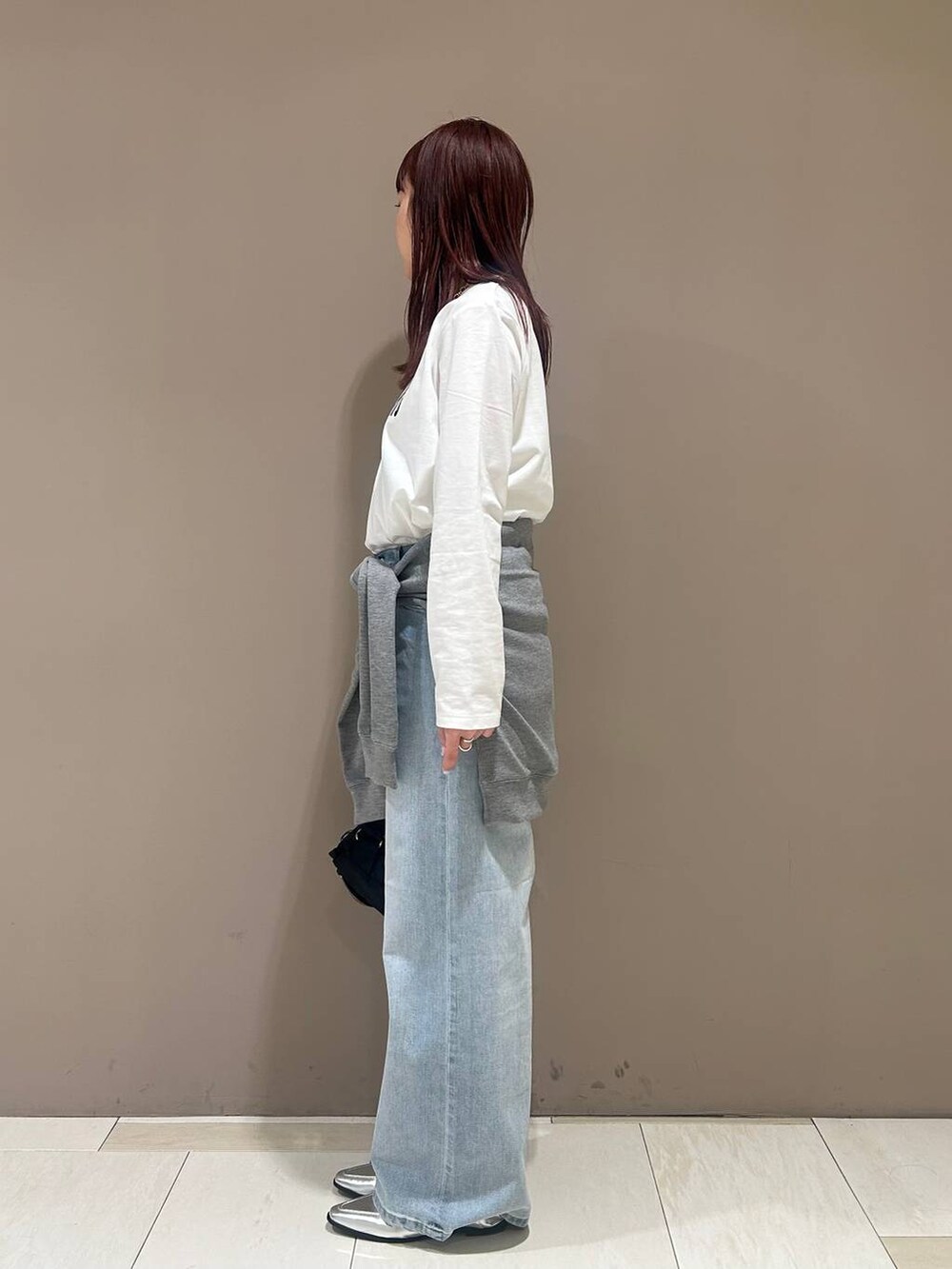 シルバー系のローファー、ブルー系のデニムパンツ、ブラック系のボディバッグ/ウエストポーチを着用したレディースの冬コーディネートの2枚目の写真