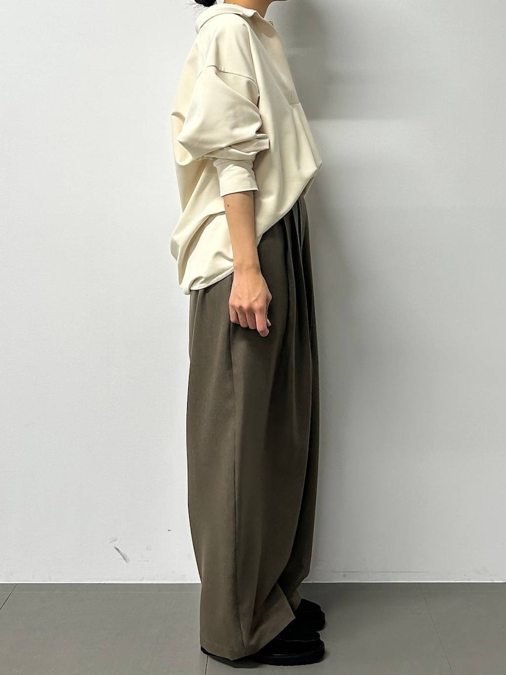 ブラック系のボストンバッグ、ブラック系のローファー、グレー系のスラックスを着用したレディースの秋コーディネートの2枚目の写真