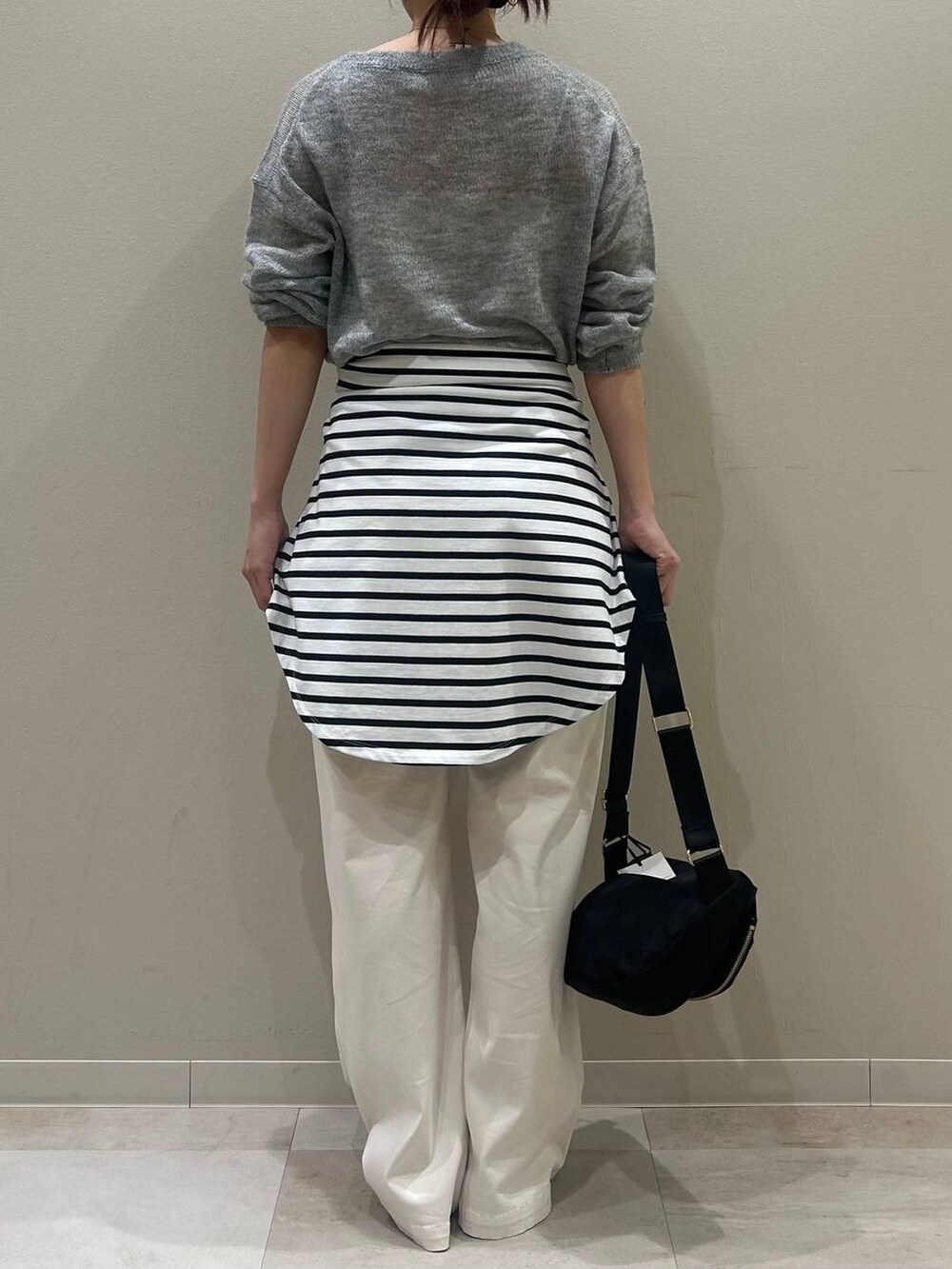 シルバー系のローファー、ブラック系のボディバッグ/ウエストポーチ、グレー系のニット/セーターを着用したレディースの冬コーディネートの3枚目の写真