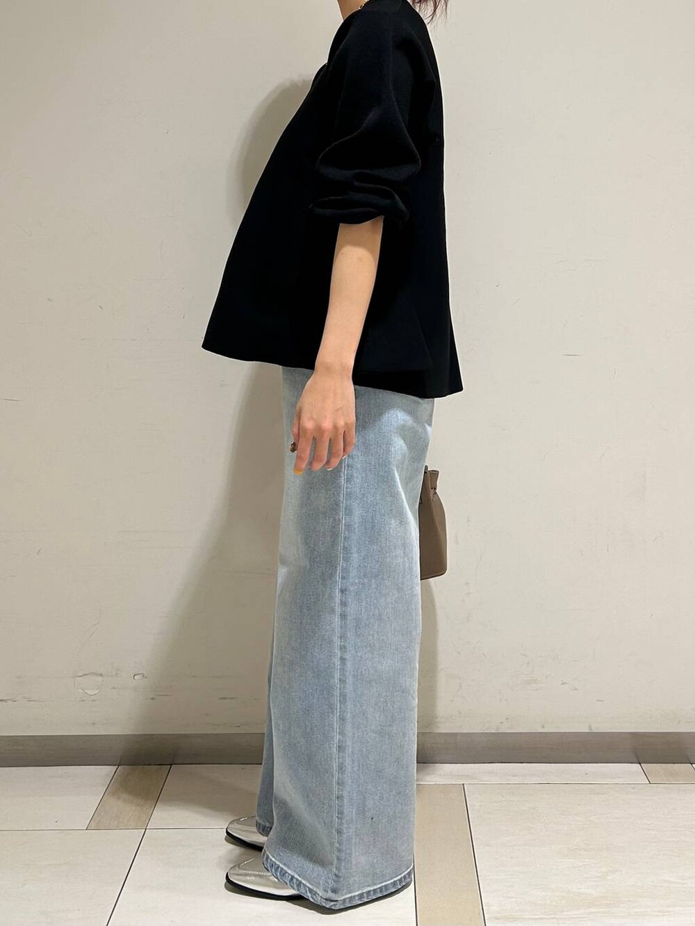 シルバー系のローファー、ブルー系のデニムパンツ、ブラック系のニット/セーターを着用したレディースの冬コーディネートの2枚目の写真