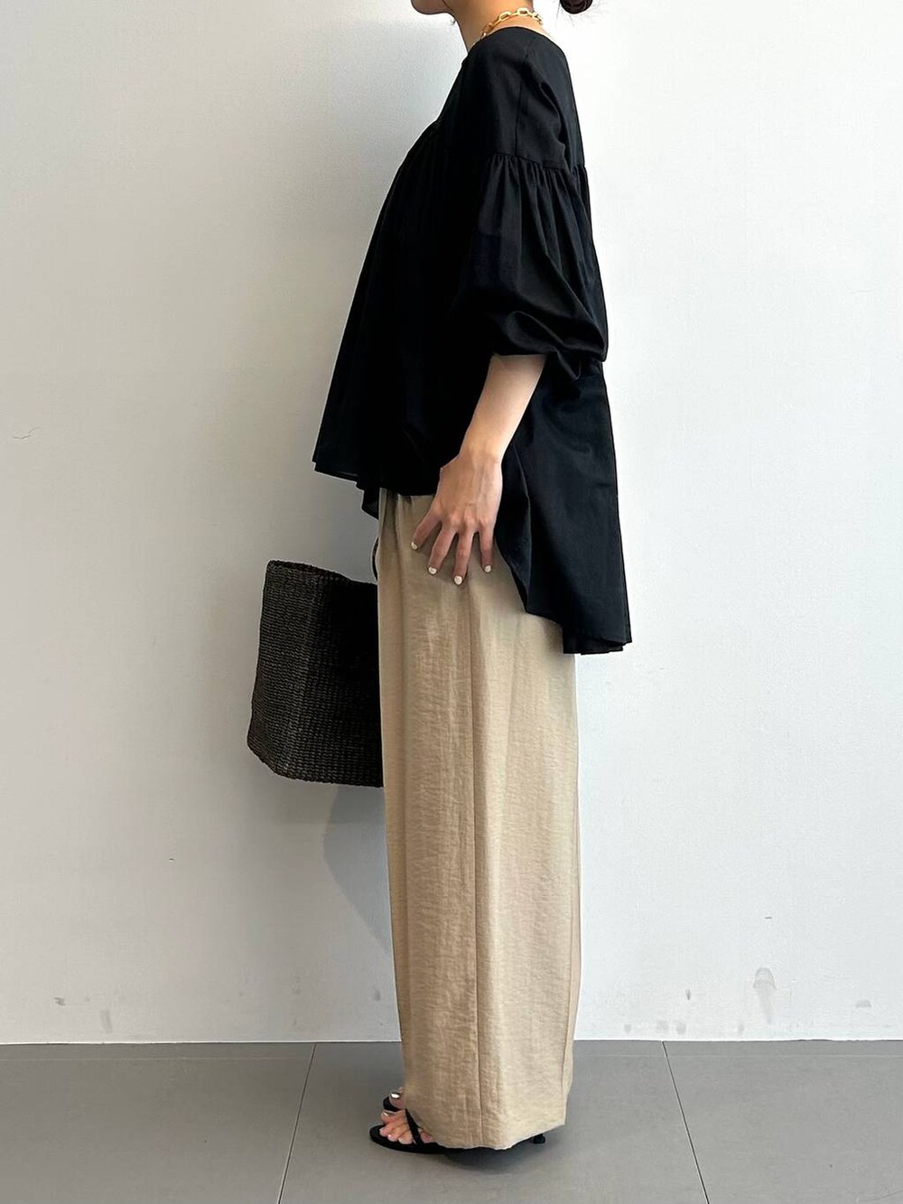 ブラウン系のかごバッグ、ブラック系のサンダル、ブラック系のシャツ/ブラウスを着用したレディースの夏コーディネートの2枚目の写真