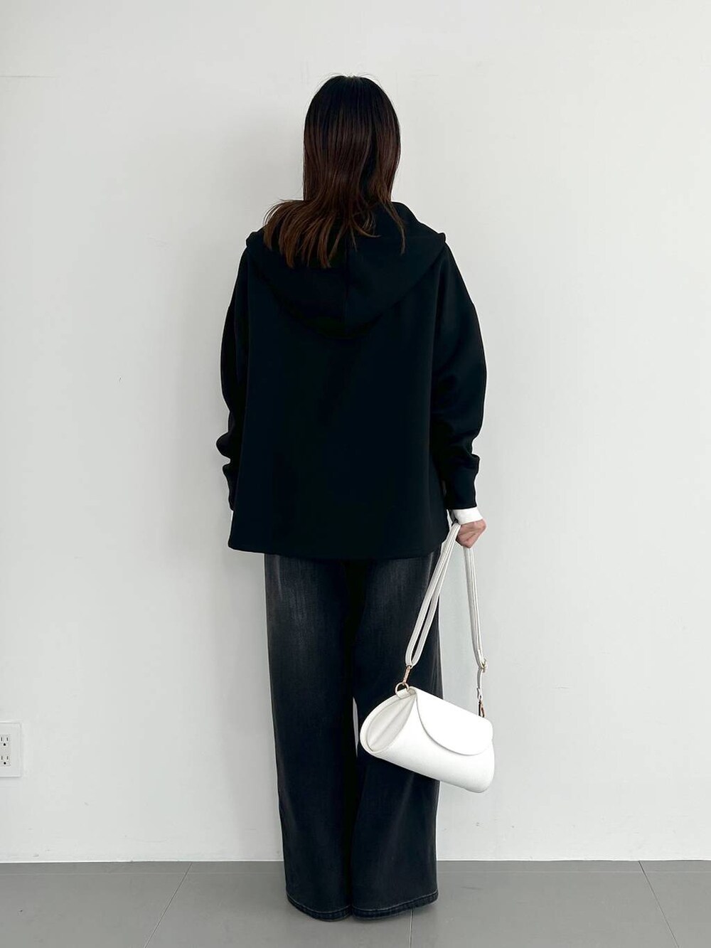 ブラック系のデニムパンツ、ホワイト系のショルダーバッグ、その他のパンプスを着用したレディースの秋コーディネートの3枚目の写真