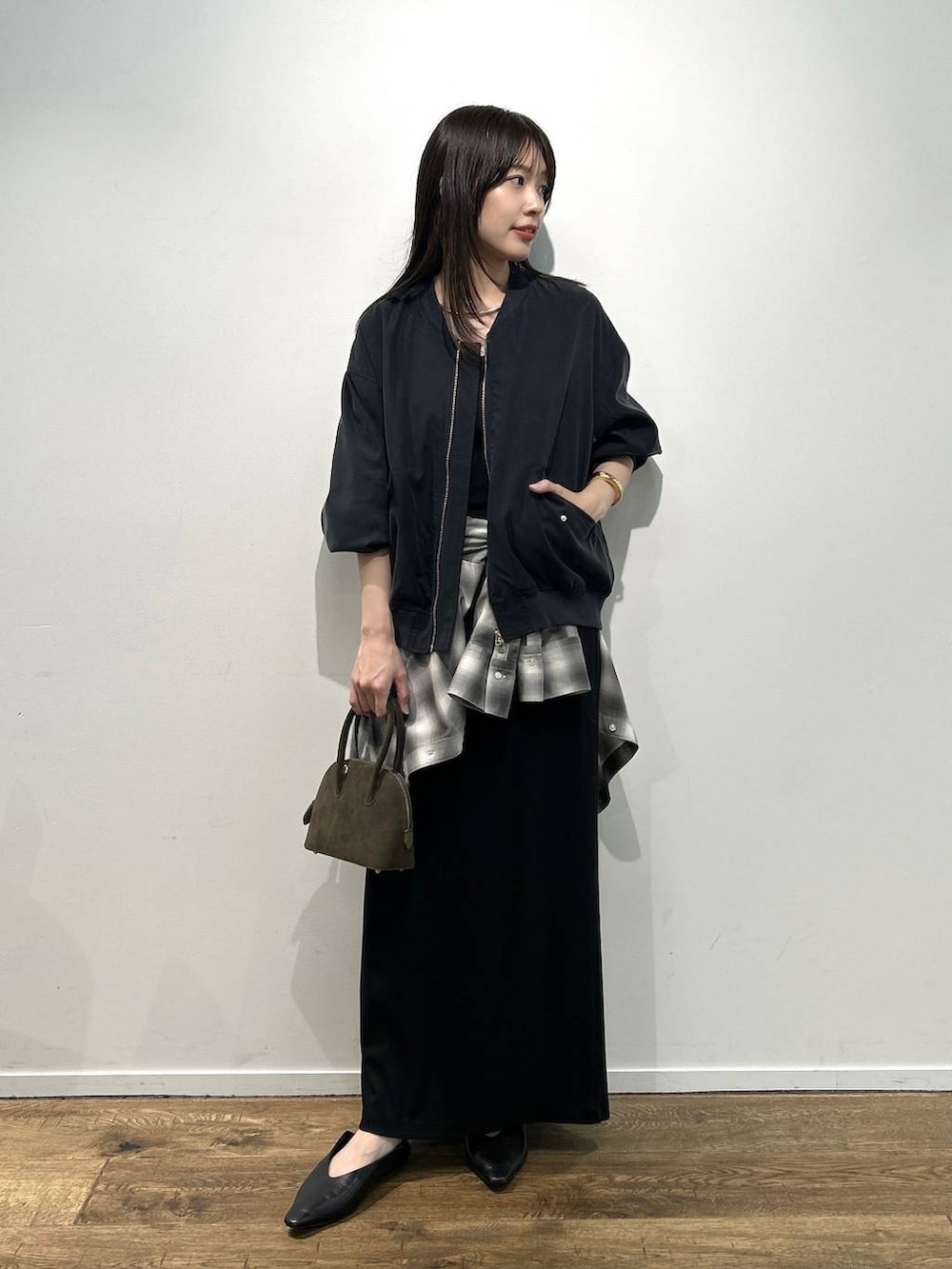 ブラック系のパンプス、ブラック系のスカート、グレー系のシャツ/ブラウスを着用したレディースの夏コーディネートの2枚目の写真