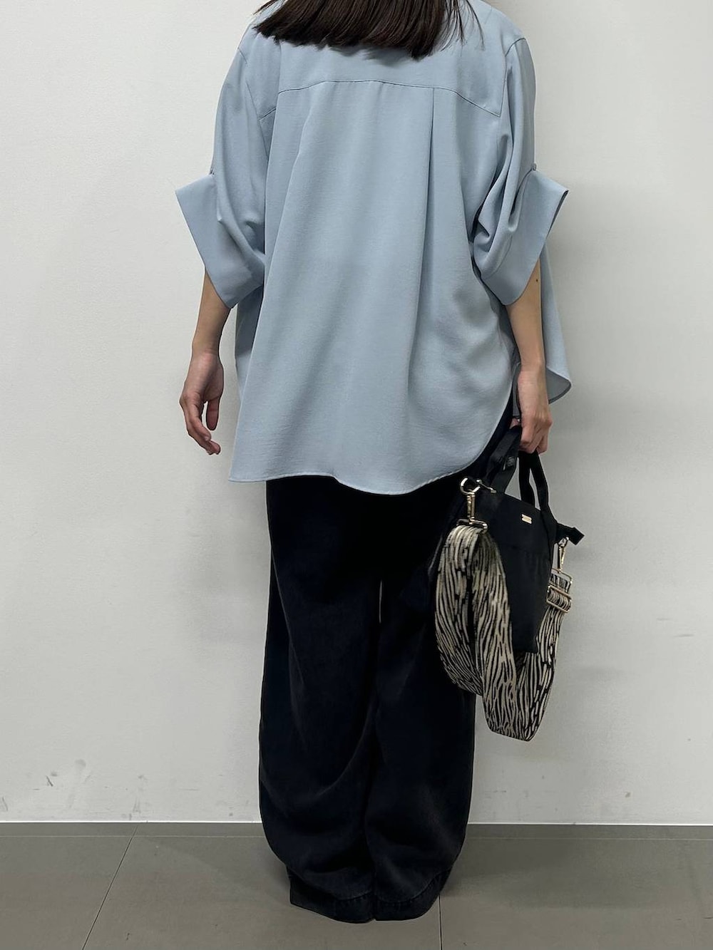 ブラック系のトートバッグ、ホワイト系のTシャツ/カットソー、ブルー系のシャツ/ブラウスを着用したレディースの春コーディネートの3枚目の写真