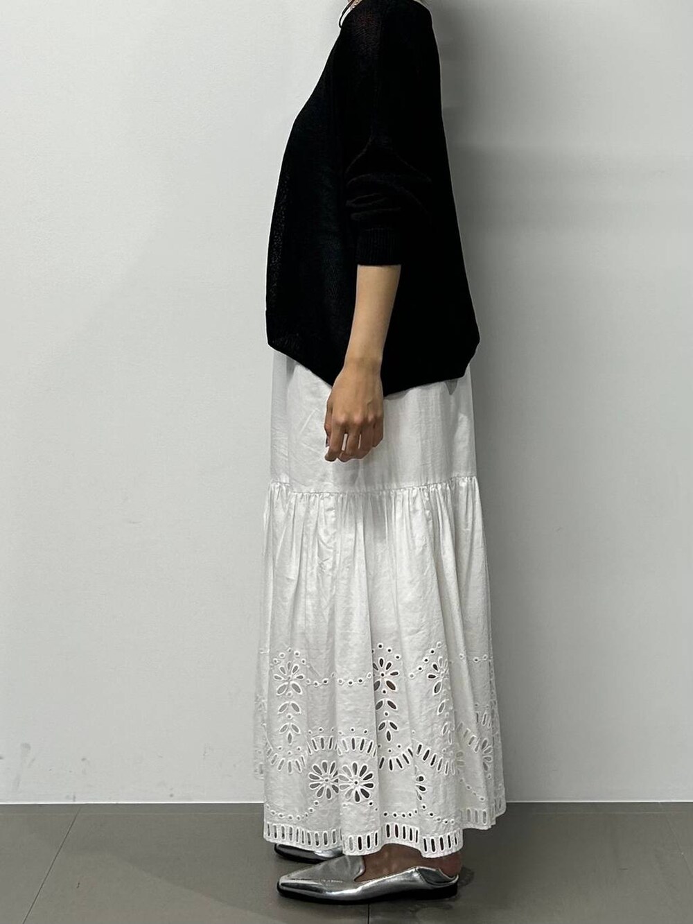 シルバー系のローファー、ブラック系のハンドバッグ、ブラック系のニット/セーターを着用したレディースの夏コーディネートの2枚目の写真