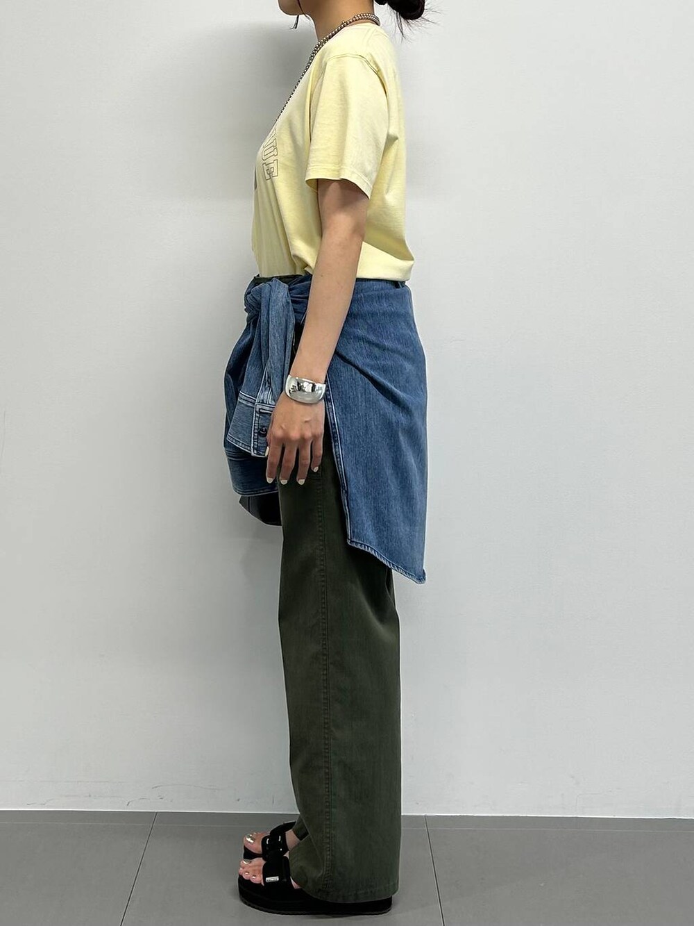 ブラック系のショルダーバッグ、ブルー系のシャツ/ブラウス、ブラック系のサンダルを着用したレディースの夏コーディネートの2枚目の写真