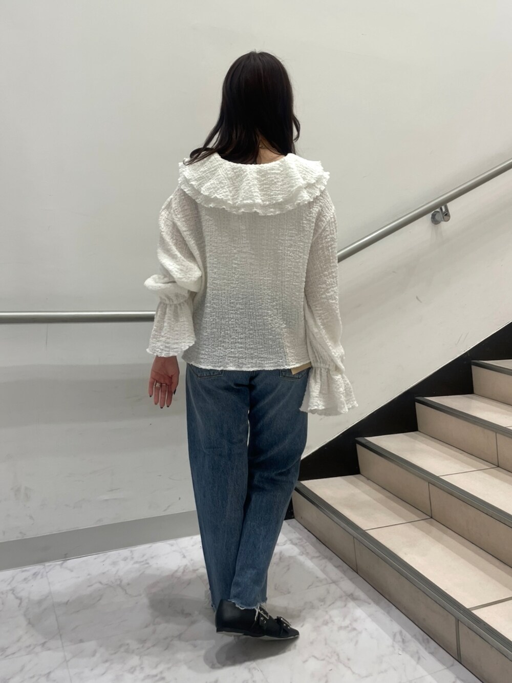 ブルー系のデニムパンツ、ホワイト系のシャツ/ブラウス、ブラック系のパンプスを着用したレディースの春コーディネートの3枚目の写真