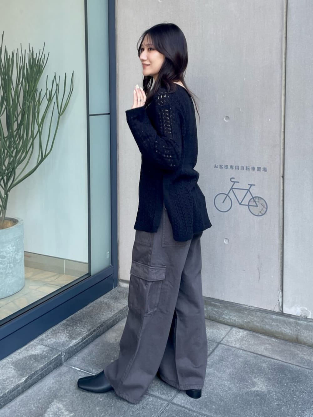 ホワイト系のキャミソール、ブラック系のニット/セーター、シルバー系のハンドバッグを着用したレディースの春コーディネートの3枚目の写真