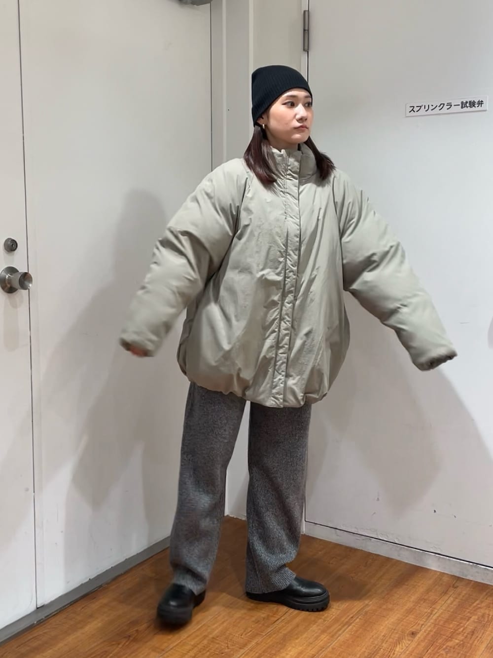 グリーン系のブルゾン、グレー系のその他パンツ、ブラック系のニットキャップ/ビーニーを着用したレディースの冬コーディネートの4枚目の写真