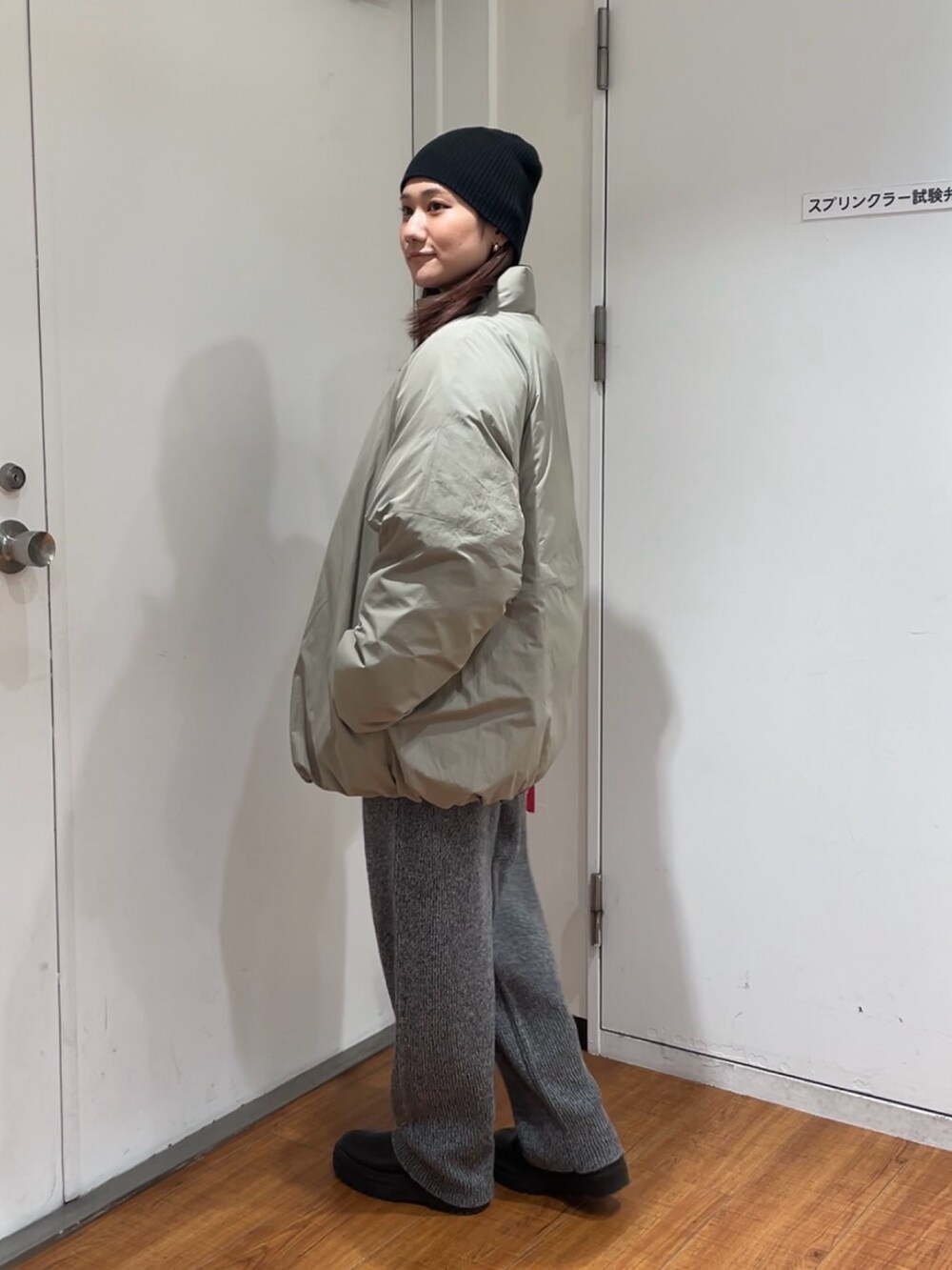 グリーン系のブルゾン、グレー系のその他パンツ、ブラック系のニットキャップ/ビーニーを着用したレディースの冬コーディネートの2枚目の写真