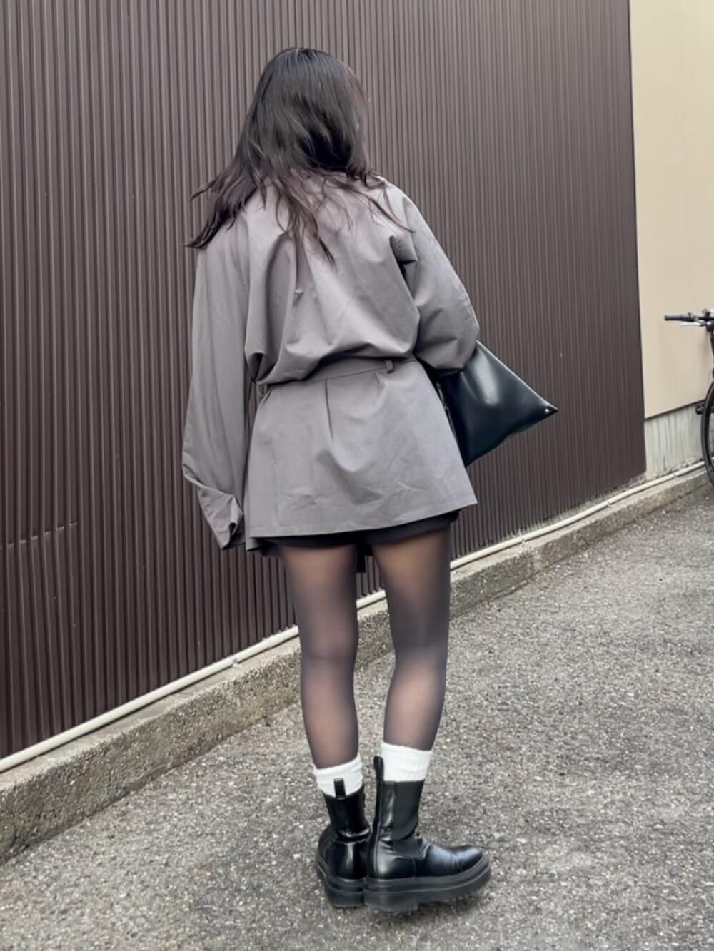 グレー系のトレンチコートを着用したレディースの冬コーディネートの3枚目の写真