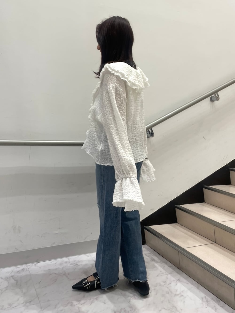 ブルー系のデニムパンツ、ホワイト系のシャツ/ブラウス、ブラック系のパンプスを着用したレディースの春コーディネートの2枚目の写真