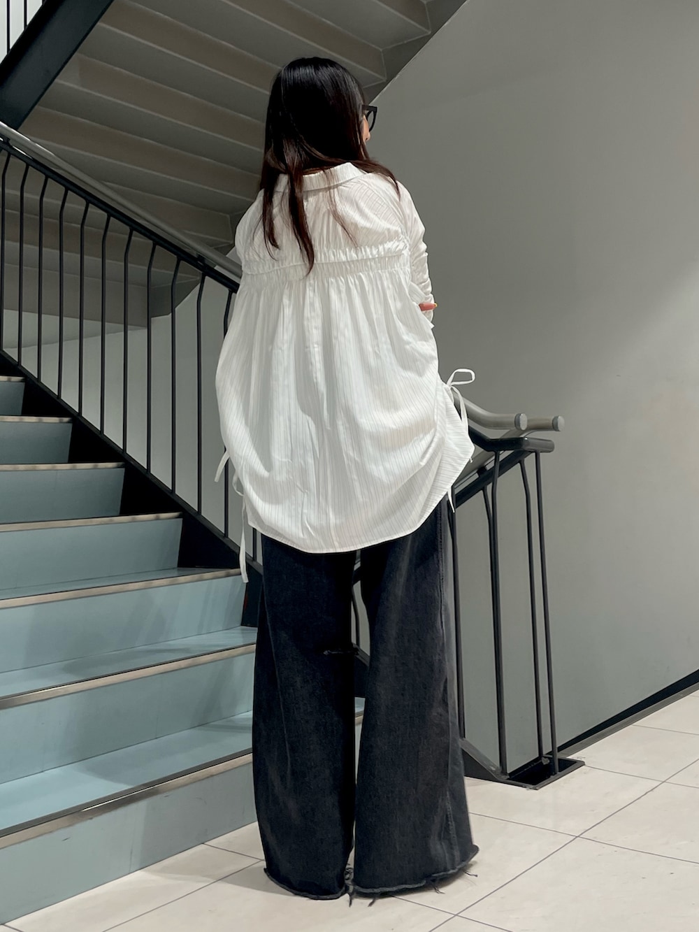 ホワイト系のシャツ/ブラウス、ブラック系のデニムパンツを着用したレディースの春コーディネートの3枚目の写真