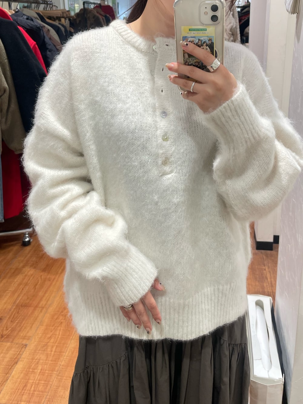 ホワイト系のニット/セーター、グレー系のスカートを着用したレディースの冬コーディネートの4枚目の写真