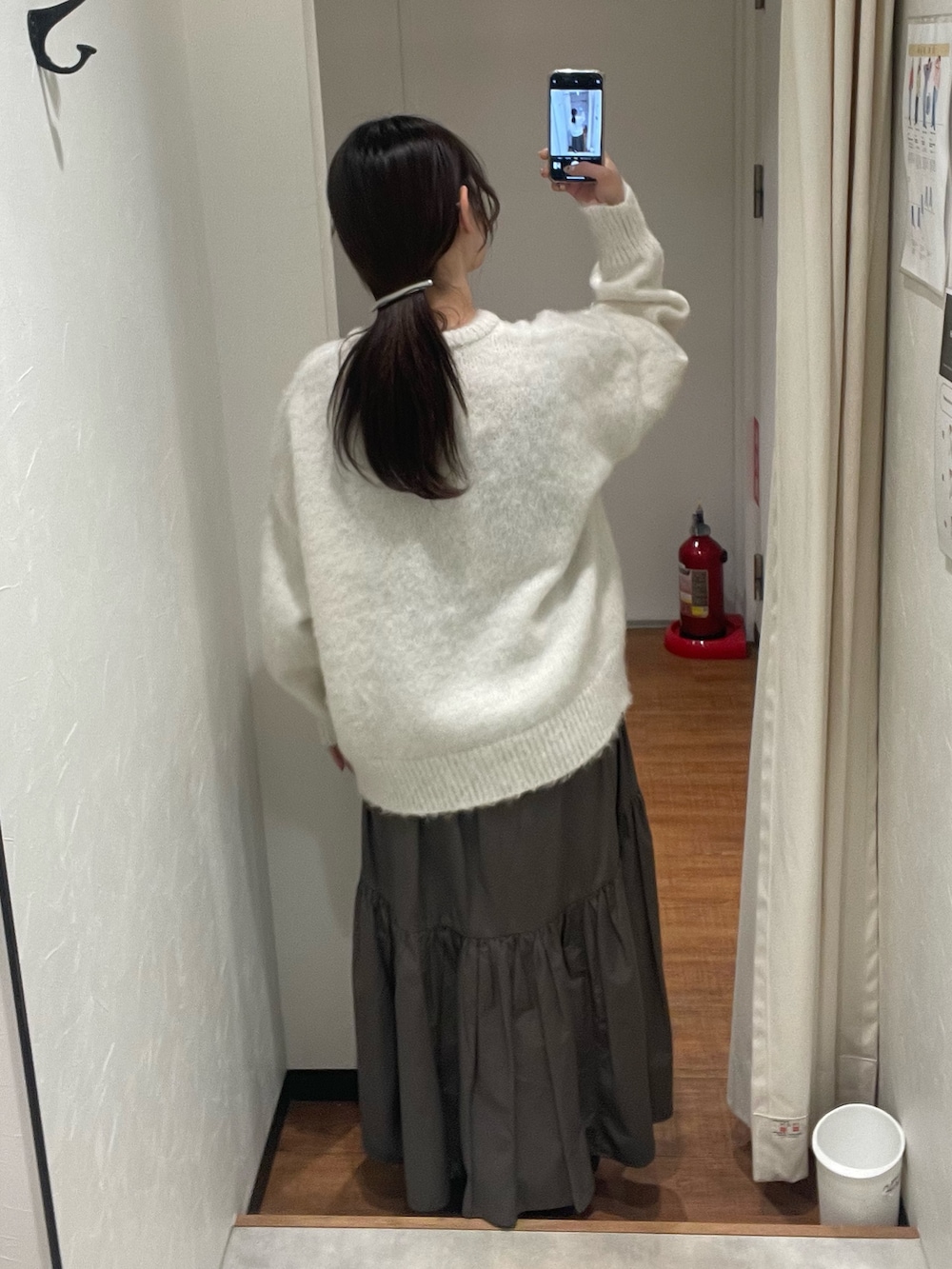 ホワイト系のニット/セーター、グレー系のスカートを着用したレディースの冬コーディネートの3枚目の写真