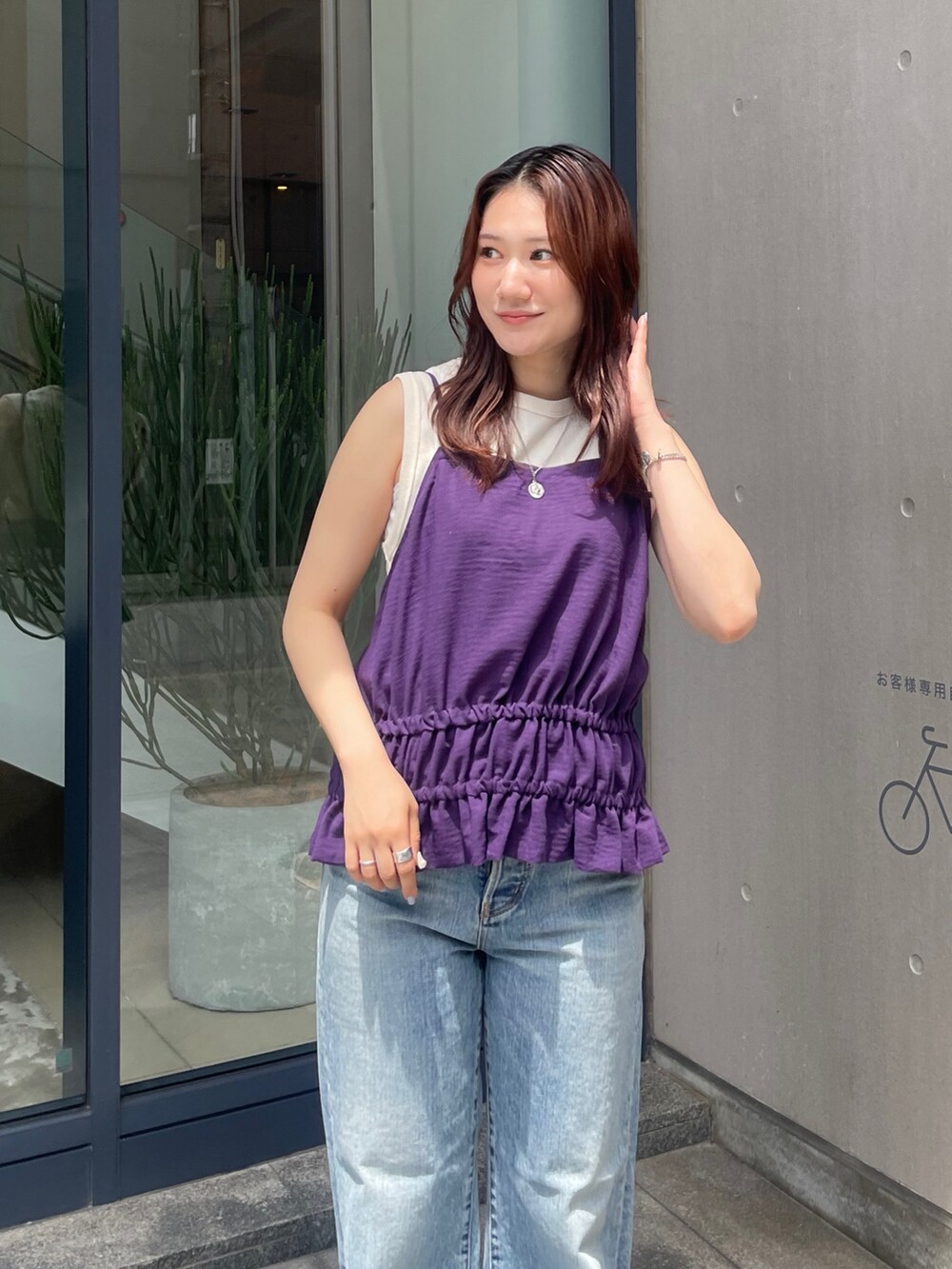 パープル系のタンクトップ、ブルー系のデニムパンツ、ブラック系のサンダルを着用したレディースの夏コーディネートの5枚目の写真