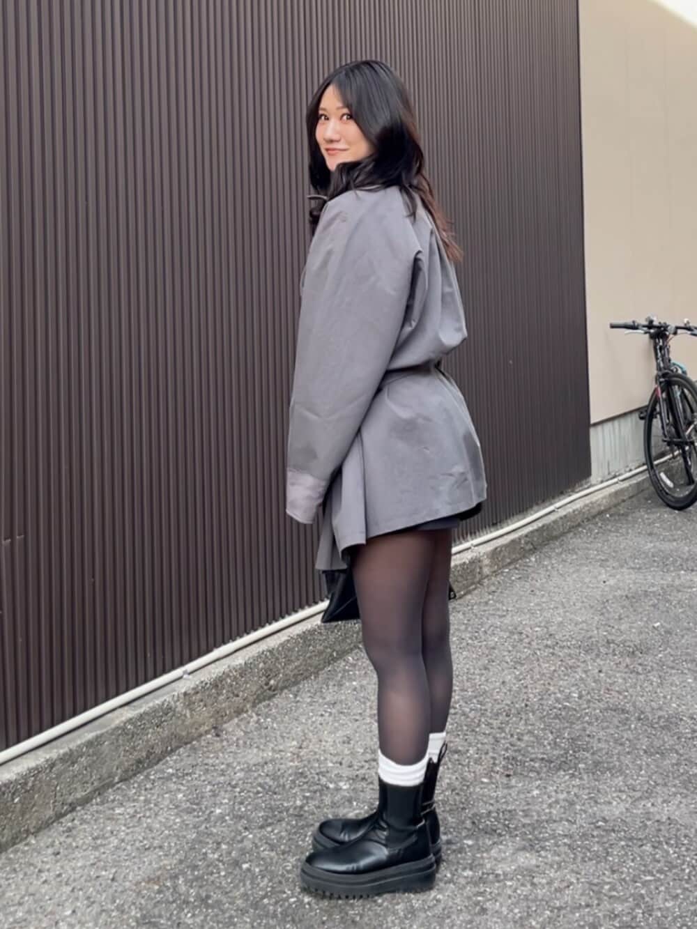 グレー系のトレンチコートを着用したレディースの冬コーディネートの2枚目の写真