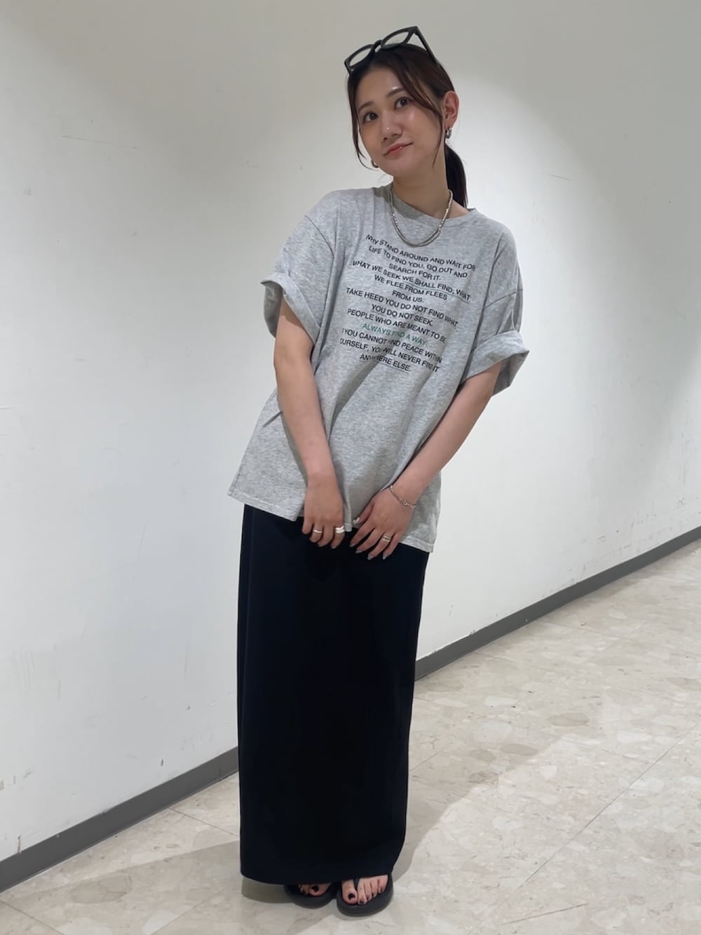 グレー系のTシャツ/カットソー、ブラック系のスカート、ブラック系のメガネを着用したレディースの夏コーディネートの2枚目の写真