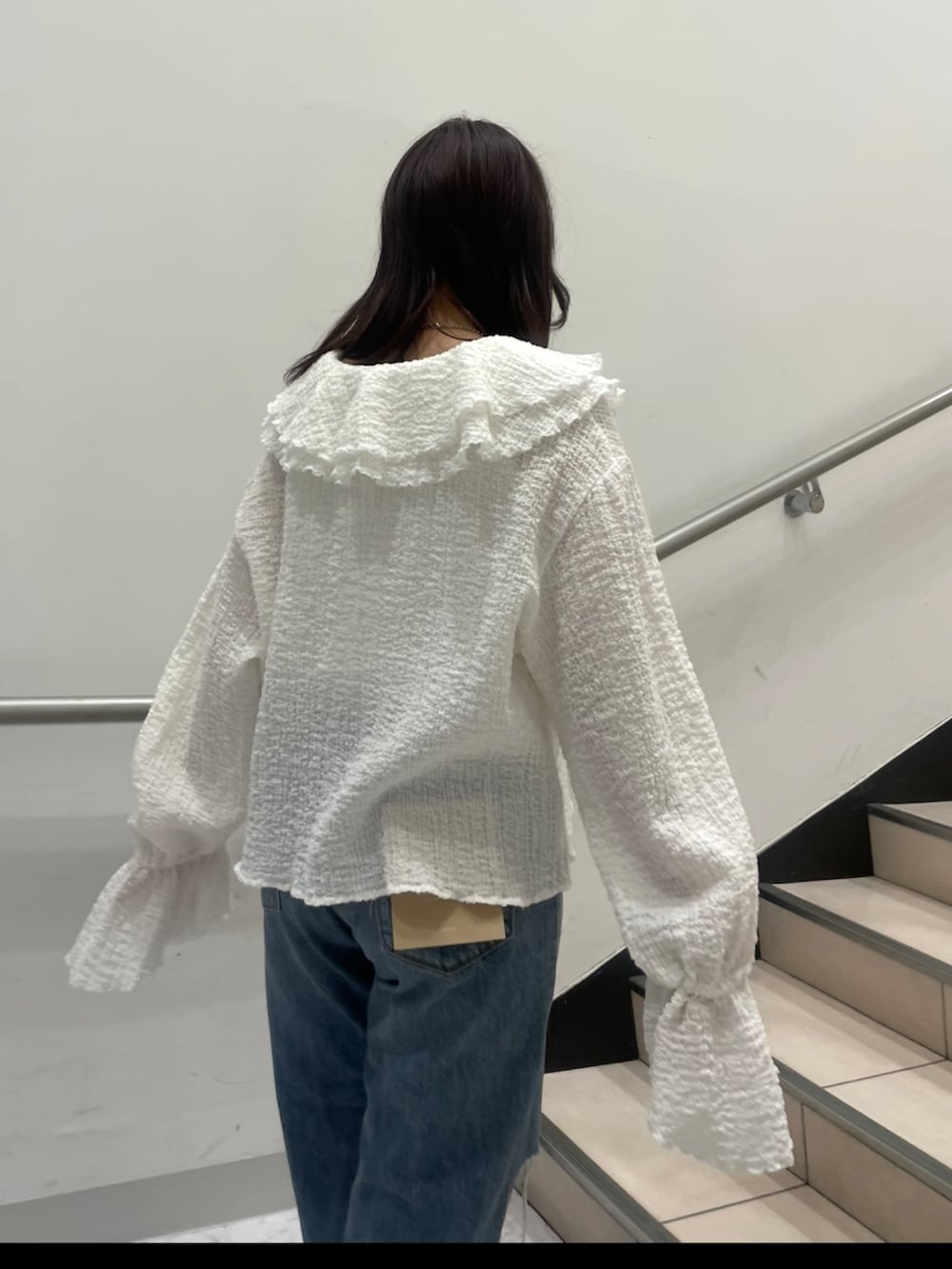 ブルー系のデニムパンツ、ホワイト系のシャツ/ブラウス、ブラック系のパンプスを着用したレディースの春コーディネートの4枚目の写真