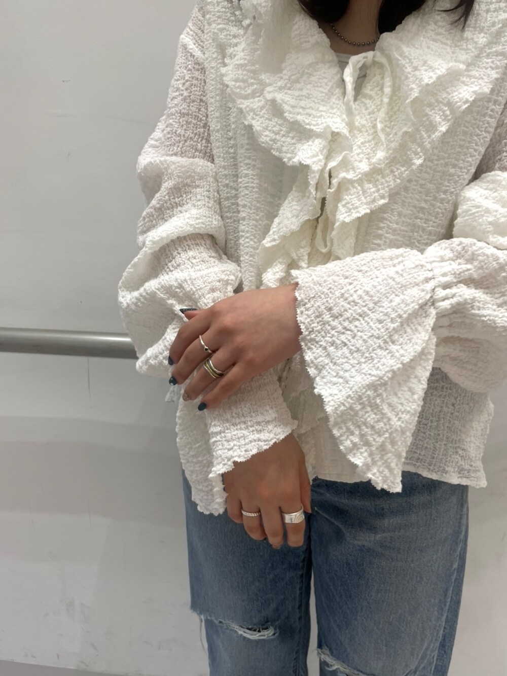 ブルー系のデニムパンツ、ホワイト系のシャツ/ブラウス、ブラック系のパンプスを着用したレディースの春コーディネートの5枚目の写真