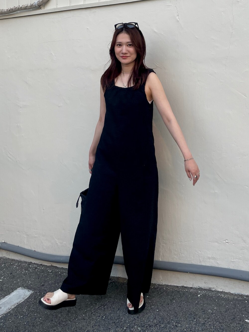 ブラック系のつなぎ/オールインワン、ホワイト系のキャミソールを着用したレディースの夏コーディネートの2枚目の写真