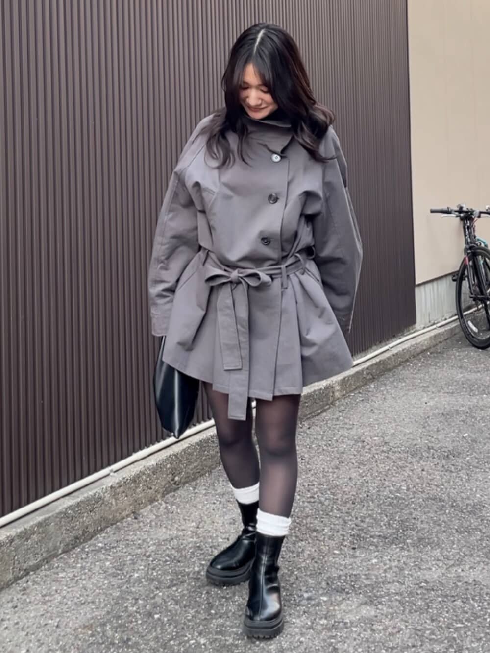 グレー系のトレンチコートを着用したレディースの冬コーディネートの4枚目の写真