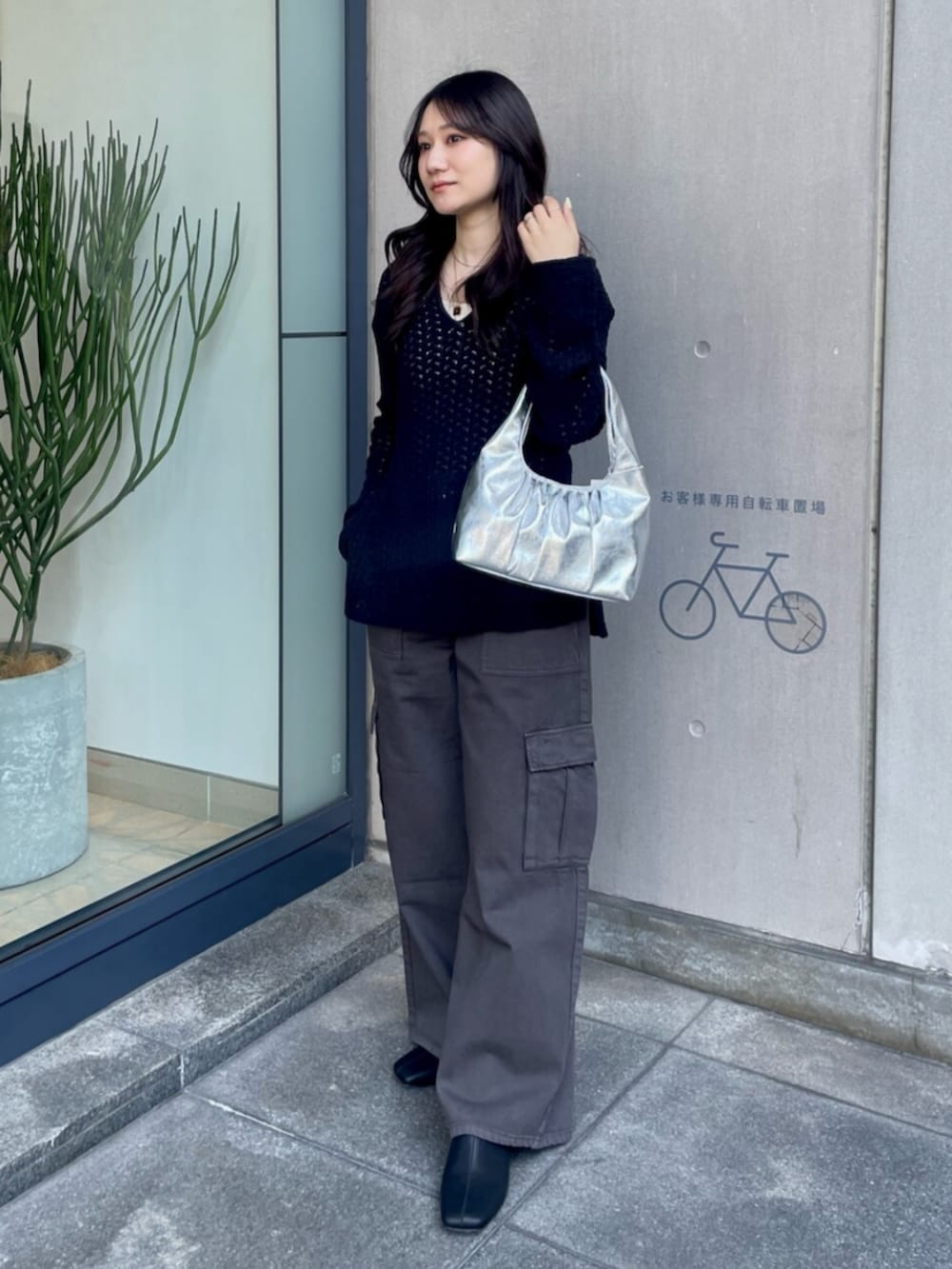 ホワイト系のキャミソール、ブラック系のニット/セーター、シルバー系のハンドバッグを着用したレディースの春コーディネートの2枚目の写真