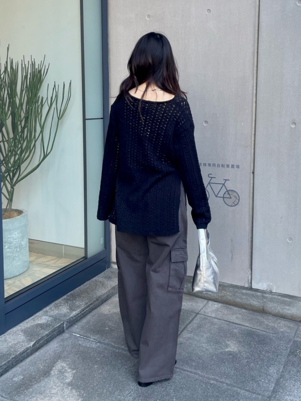 ホワイト系のキャミソール、ブラック系のニット/セーター、シルバー系のハンドバッグを着用したレディースの春コーディネートの4枚目の写真