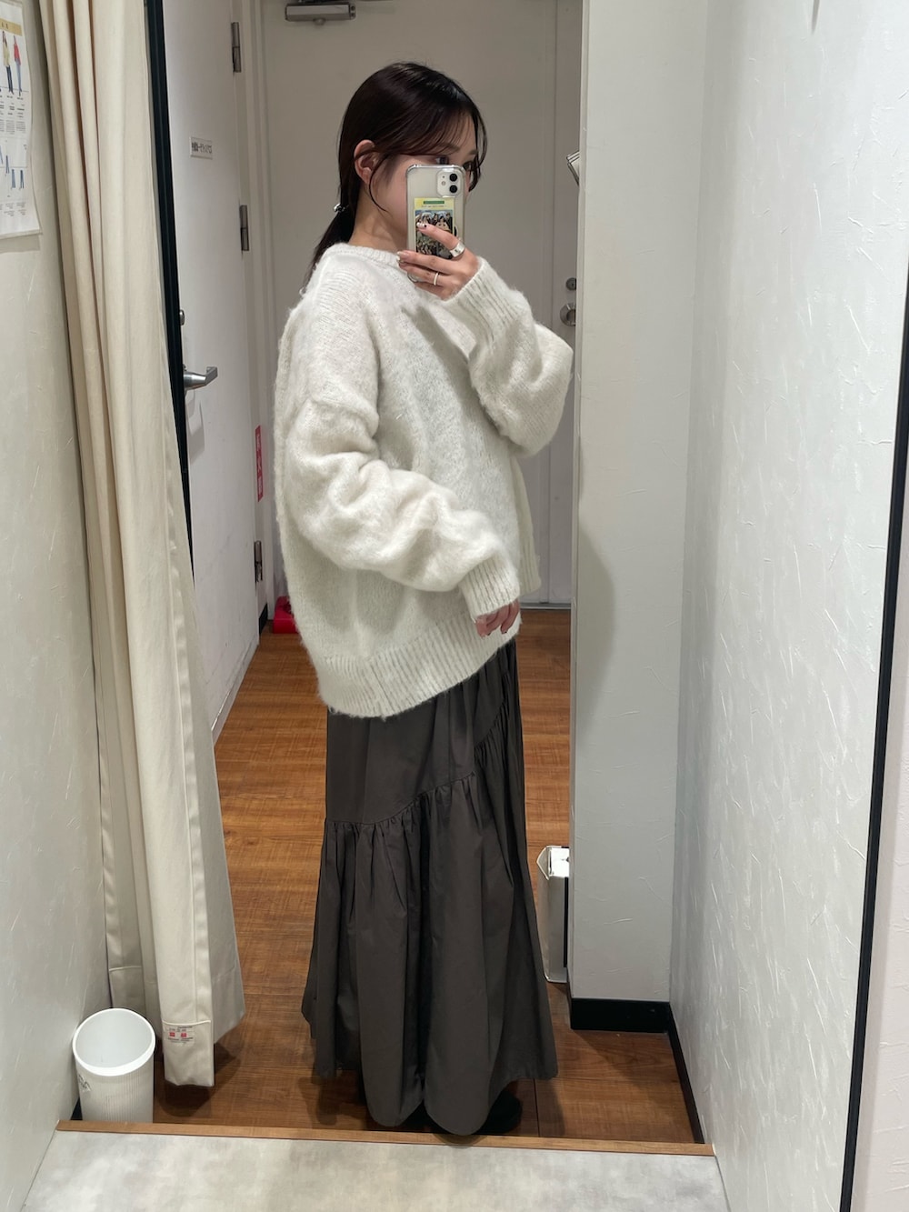 ホワイト系のニット/セーター、グレー系のスカートを着用したレディースの冬コーディネートの2枚目の写真