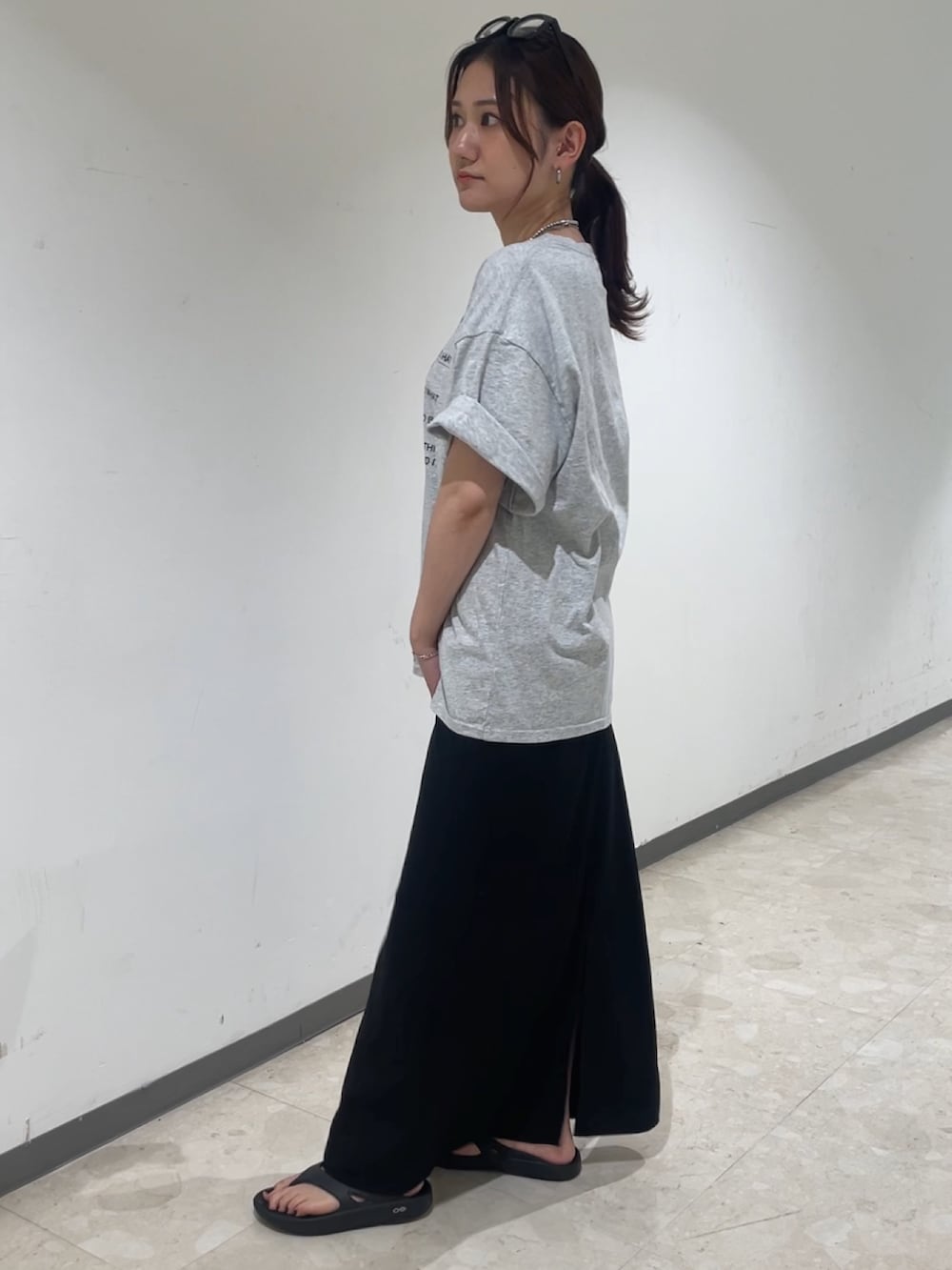 グレー系のTシャツ/カットソー、ブラック系のスカート、ブラック系のメガネを着用したレディースの夏コーディネートの3枚目の写真